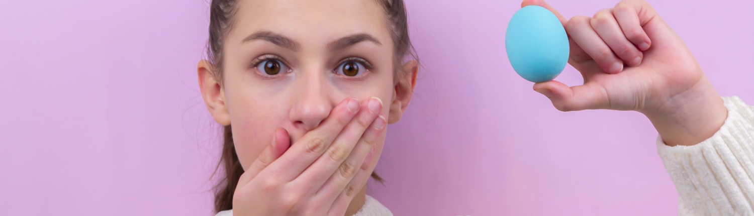 woman in white sweater holding blue balloon